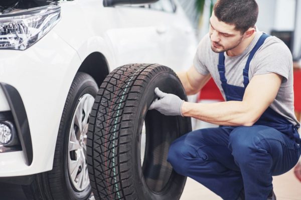 mechanic-holding-tire-tire-repair-garage-replacement-winter-summer-tires